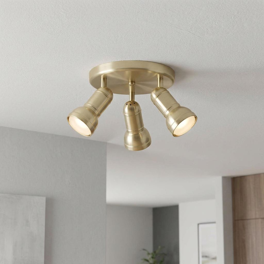 Three-way adjustable antique brass plate spotlight fixture mounted on a white ceiling.