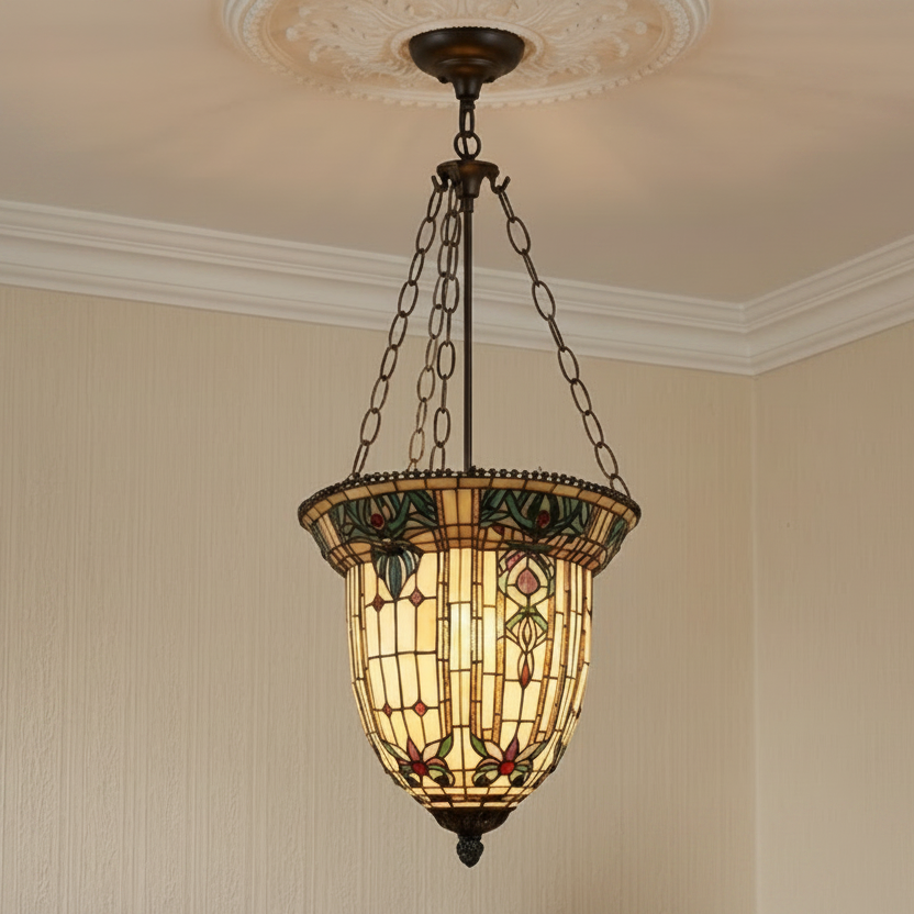 A vintage-style stained glass pendant light hanging from a chain in a room with beige walls and white crown molding.