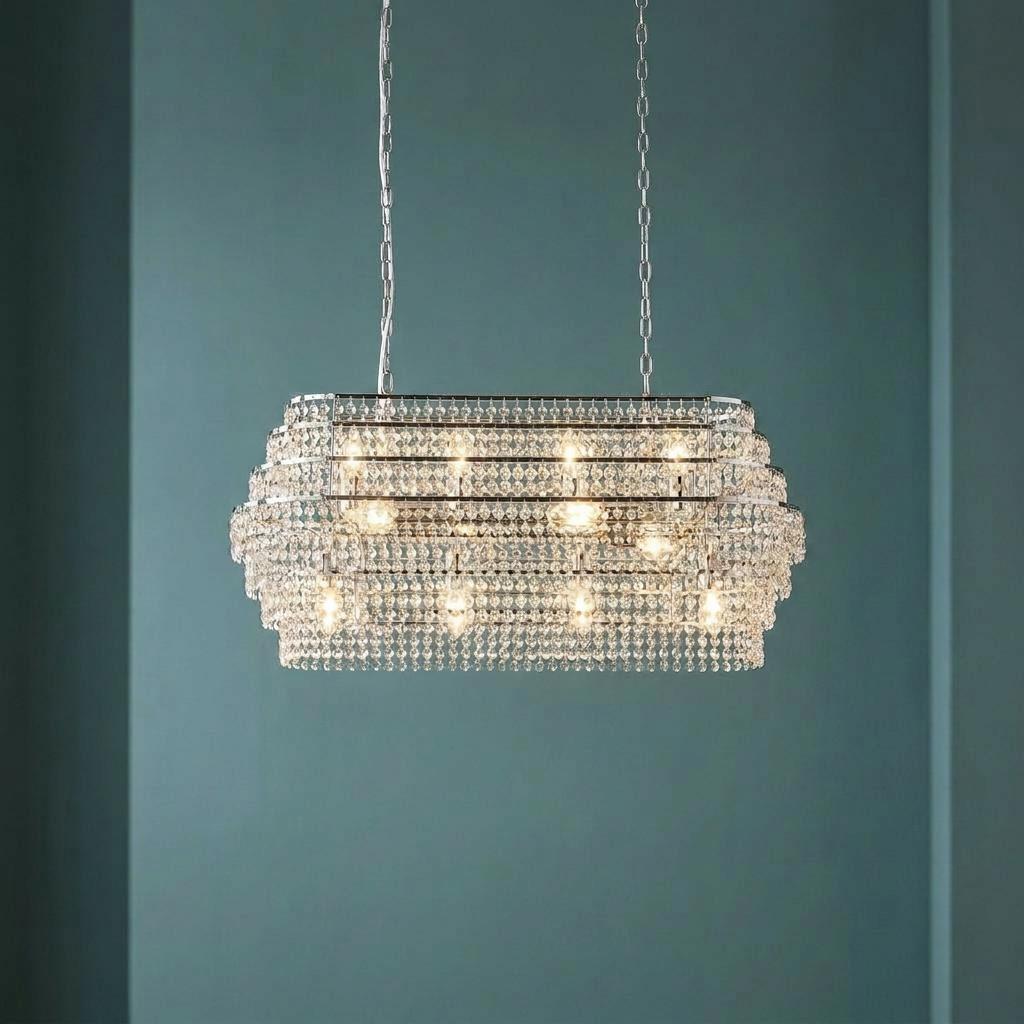 Rectangular chrome ceiling pendant light featuring tiers of shimmering hanging crystals against a blue background.