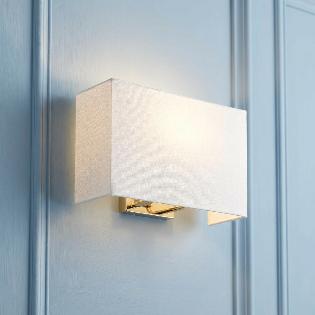 Rectangular cream fabric wall light with a polished chrome base mounted on a decorative light blue paneled wall.