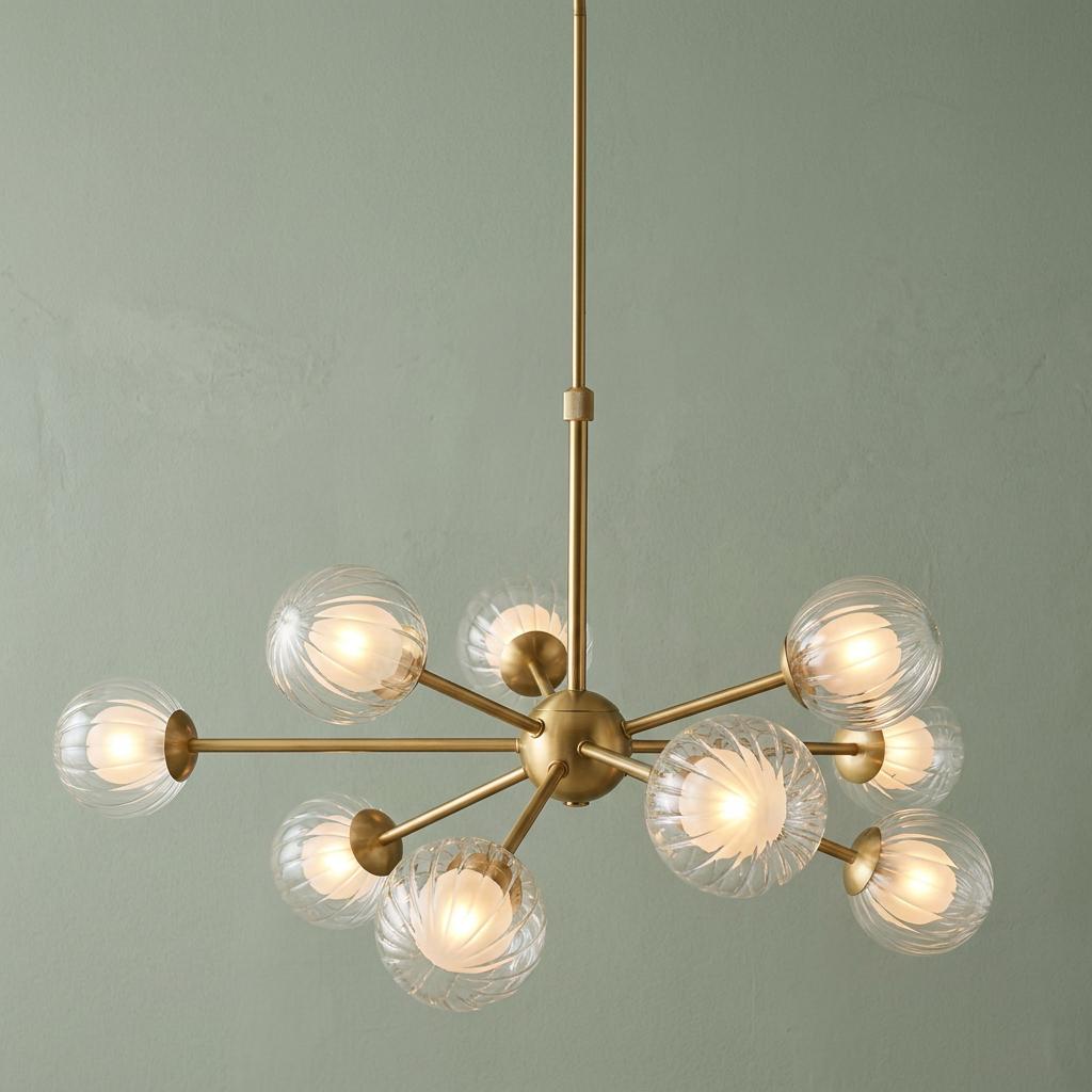 Riviera 9-light brass Sputnik pendant with ribbed glass globes against a sage green wall.
