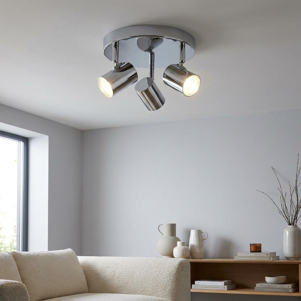 Rollo 3 light chrome cylinder head flush spotlight mounted on a white ceiling in a modern minimalist living room.