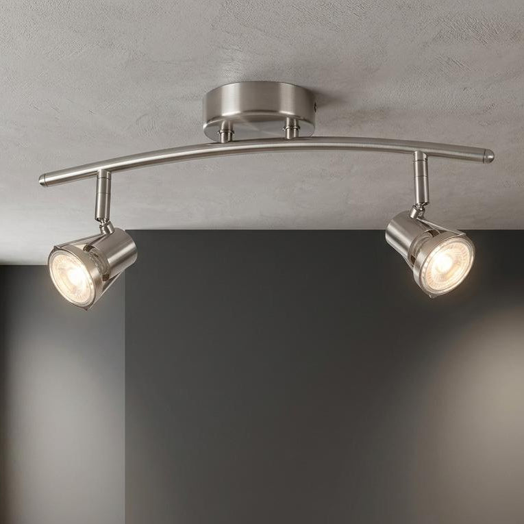 Romore Antique Chrome Finish 2 light spotlight on a textured ceiling, illuminating a dark grey wall in a modern room.