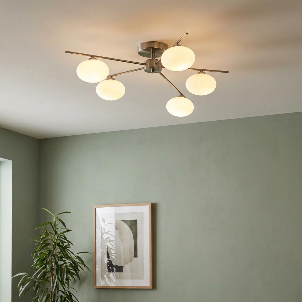 Five-light antique chrome semi-flush ceiling light with opal glass globes in a room with sage green walls.