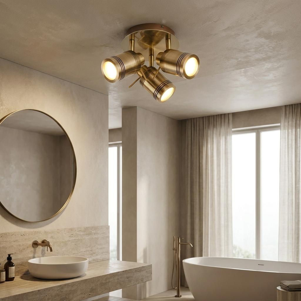 Samson 3 light brass adjustable flush spotlight illuminates a modern bathroom with a round mirror and bathtub.