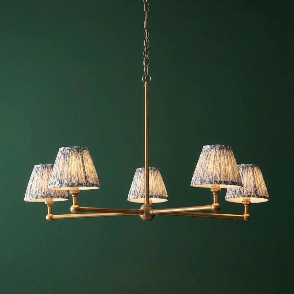 Santiago brass 5-light pendant with grey leaf pattern shades against a dark green wall.