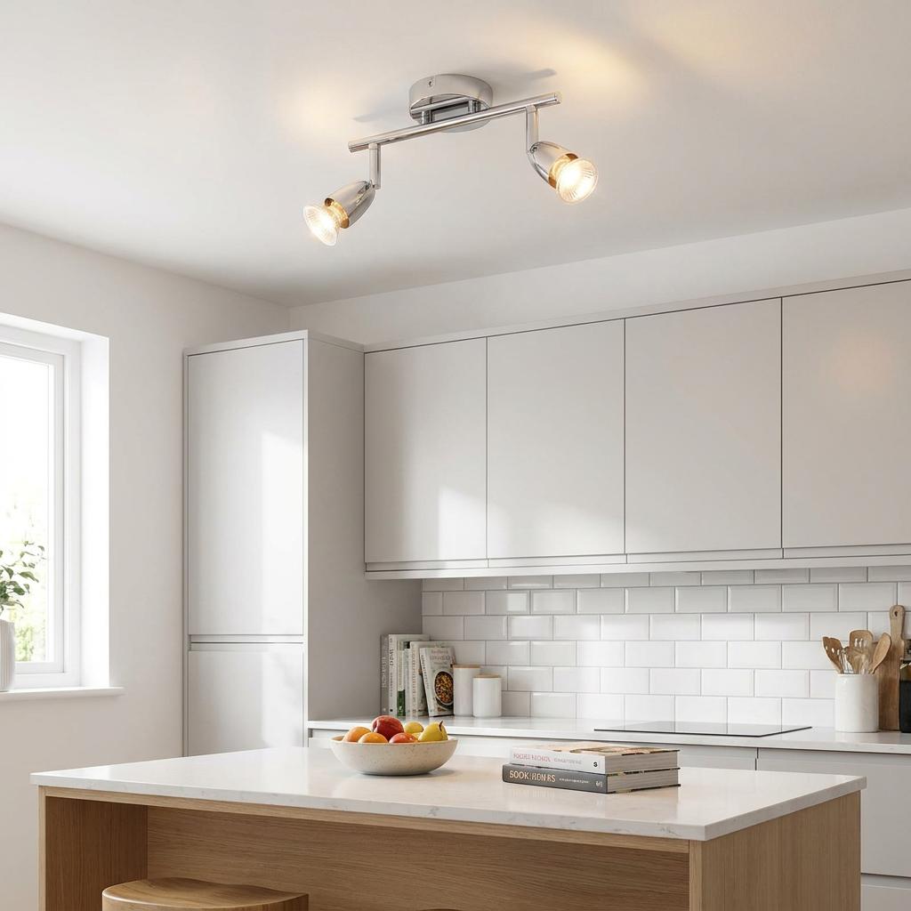 Chrome 2-light spotlight bar mounted on a white ceiling in a bright, modern kitchen.