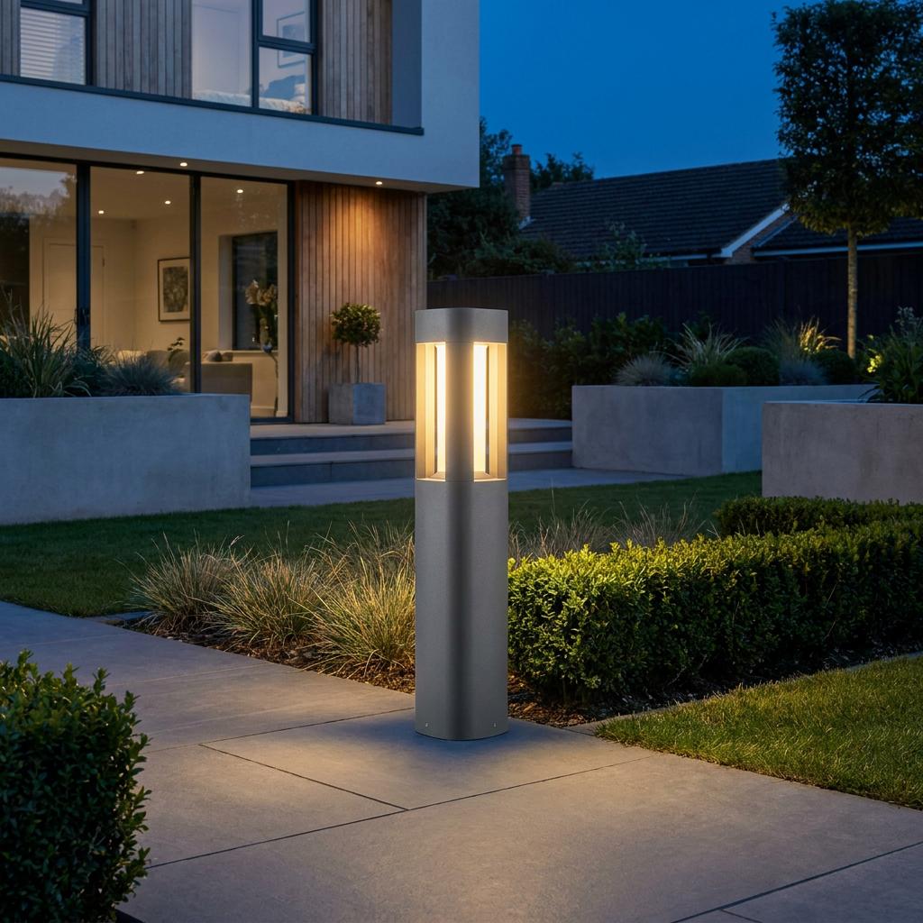 Sleek grey LED bollard light illuminating a modern garden path at dusk.