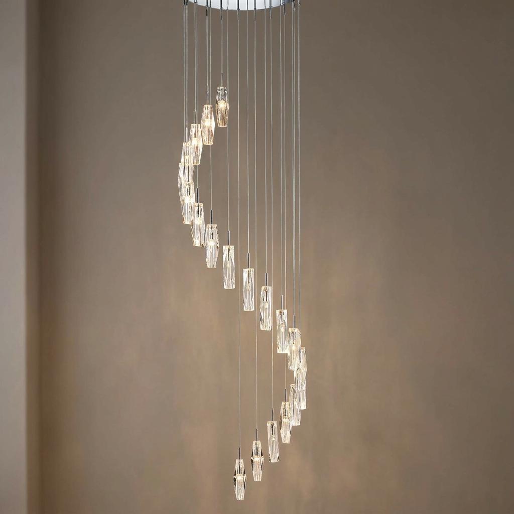 Modern spiral chandelier with 20 K9 glass textured drops on a chrome base against a neutral wall.