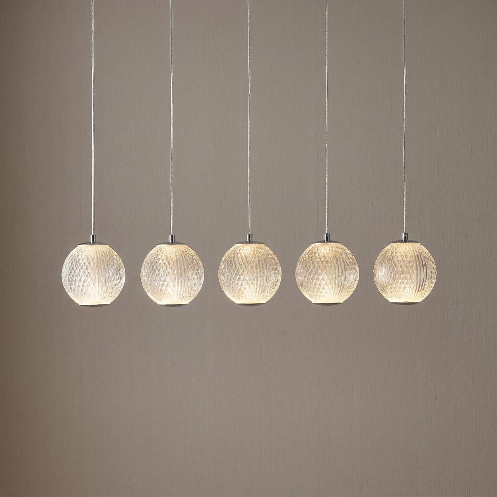 Five illuminated textured glass sphere pendant lights hanging in a row against a neutral background.