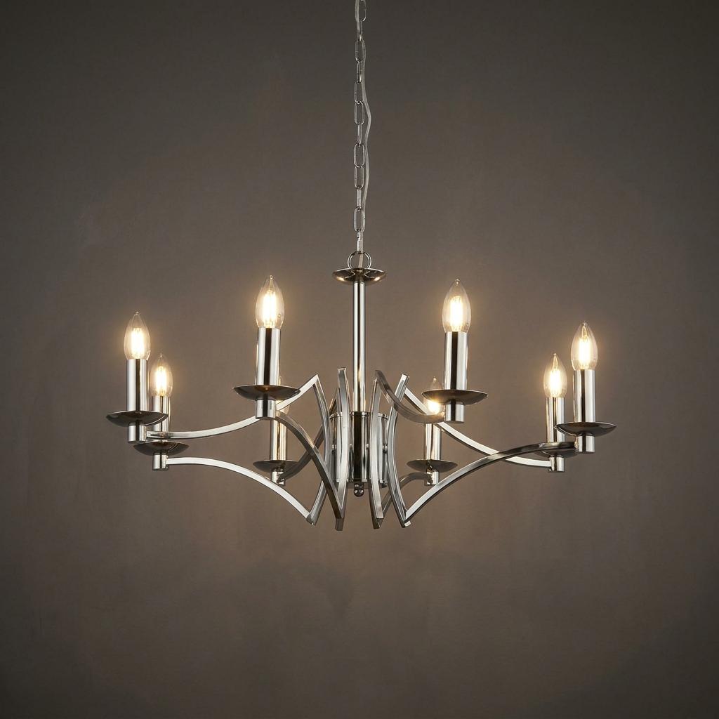Polished chrome 8-light chandelier with curved arms and lit candle bulbs against a dark grey background.