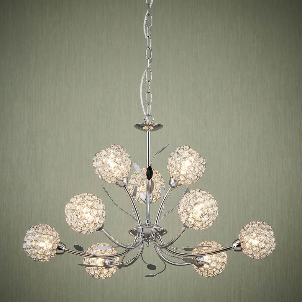 Nine-light chrome chandelier featuring delicate glass crystal ball shades and leaf accents on a green wall.