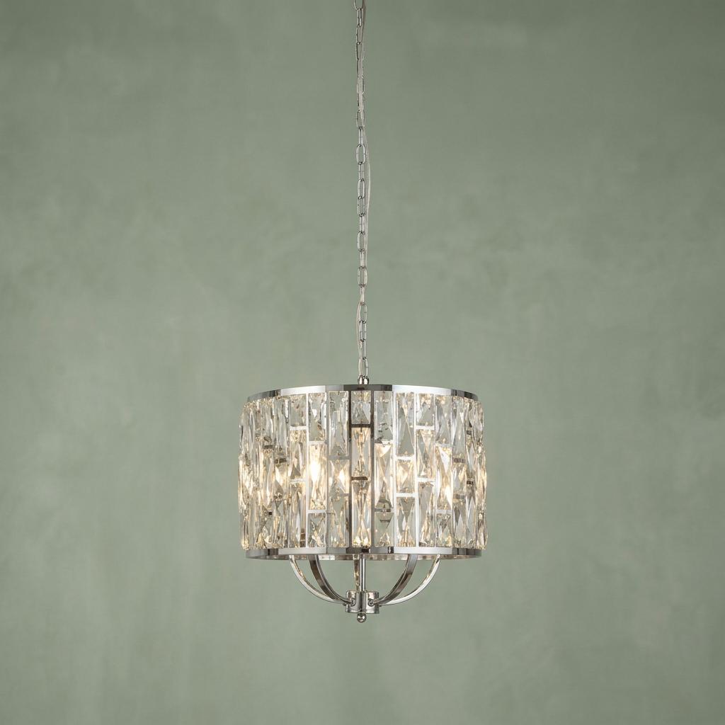 Searchlight Bijou 5-light chrome pendant with a crystal glass drum shade glowing against a green textured wall.