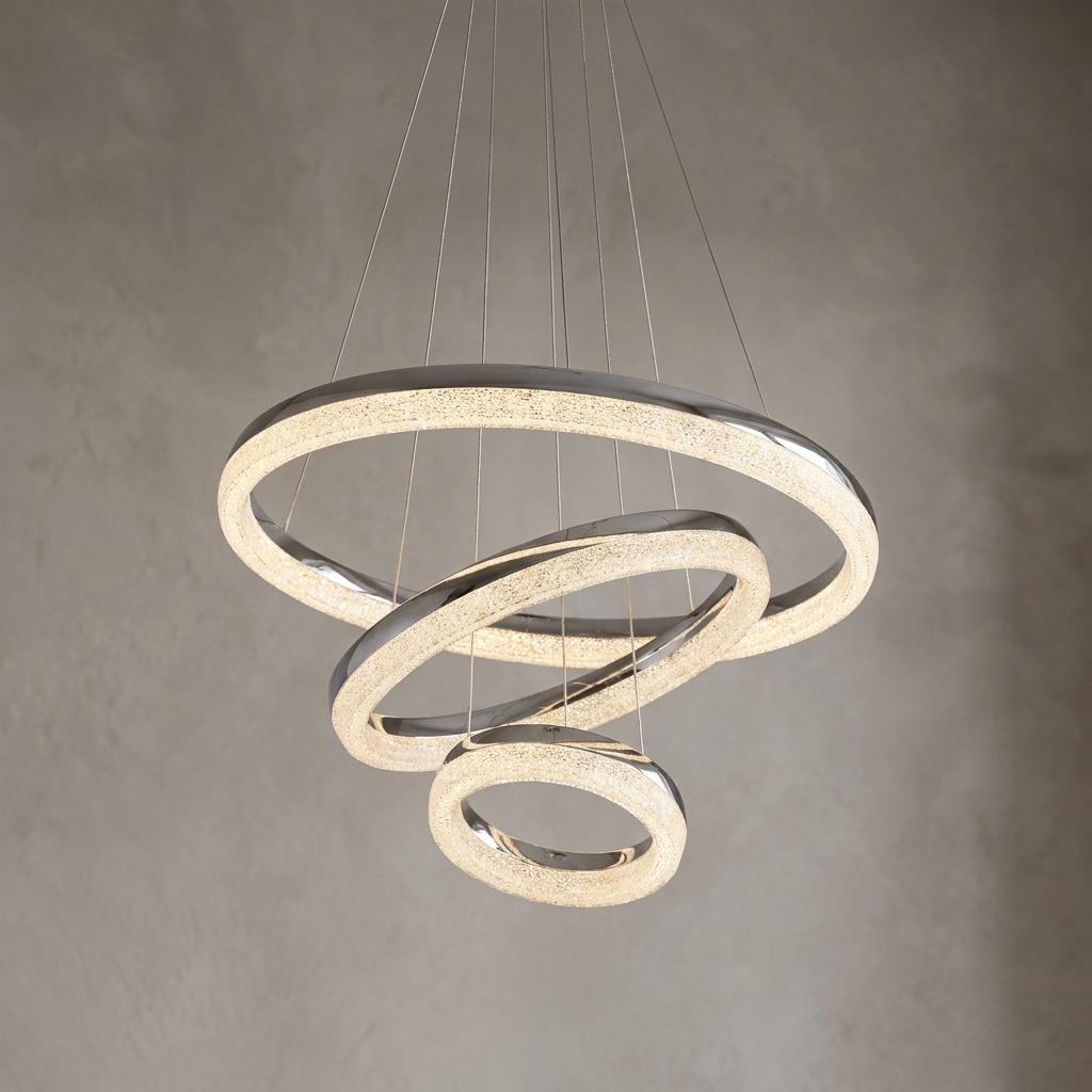 Chrome three-ring LED pendant light with crushed ice crystal effect suspended against a neutral wall.