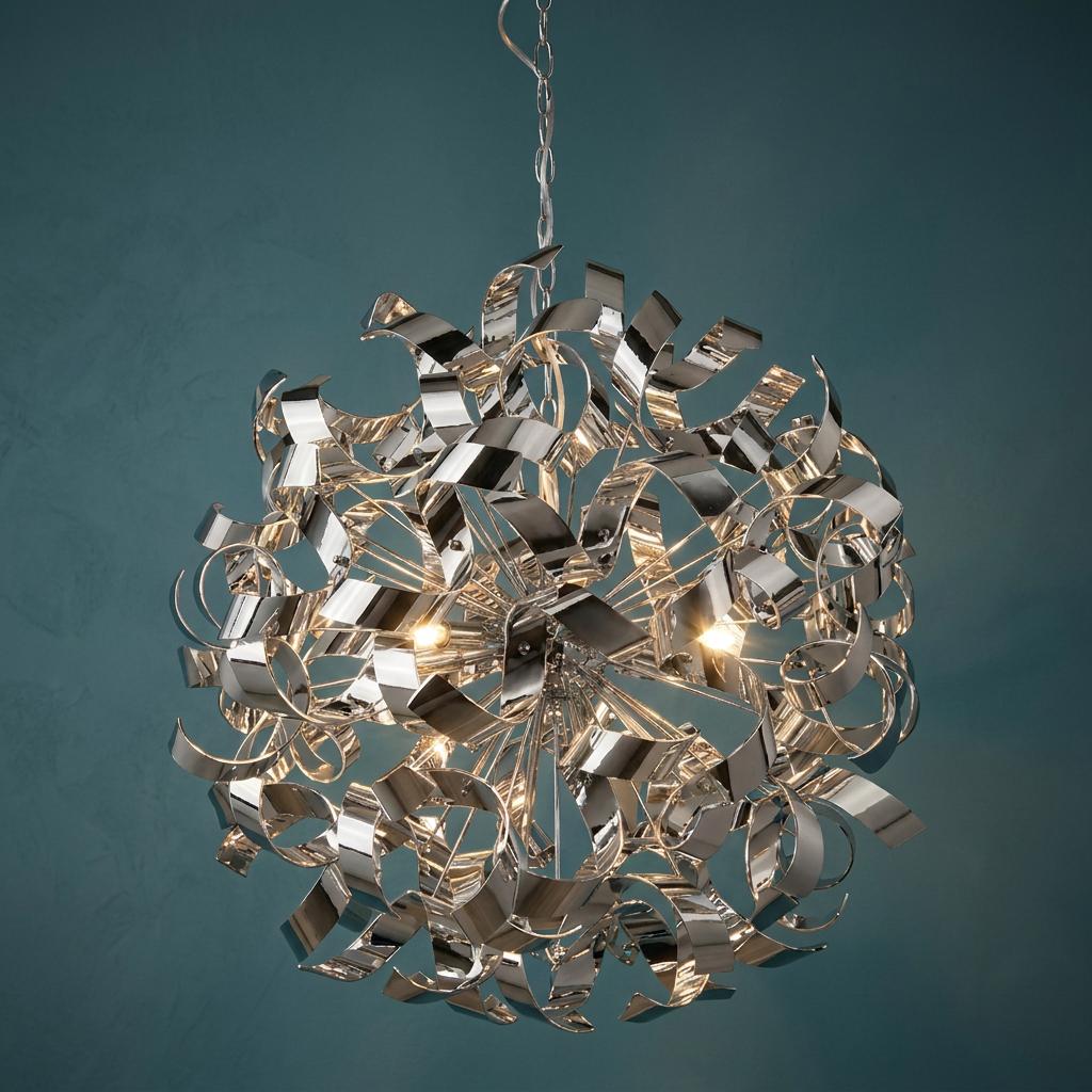 A spherical chrome pendant light featuring illuminated metallic curls hanging against a dark teal wall.