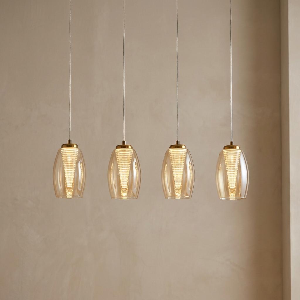 Four cyclone pendant lights with bronze caps and champagne glass shades against a beige wall.