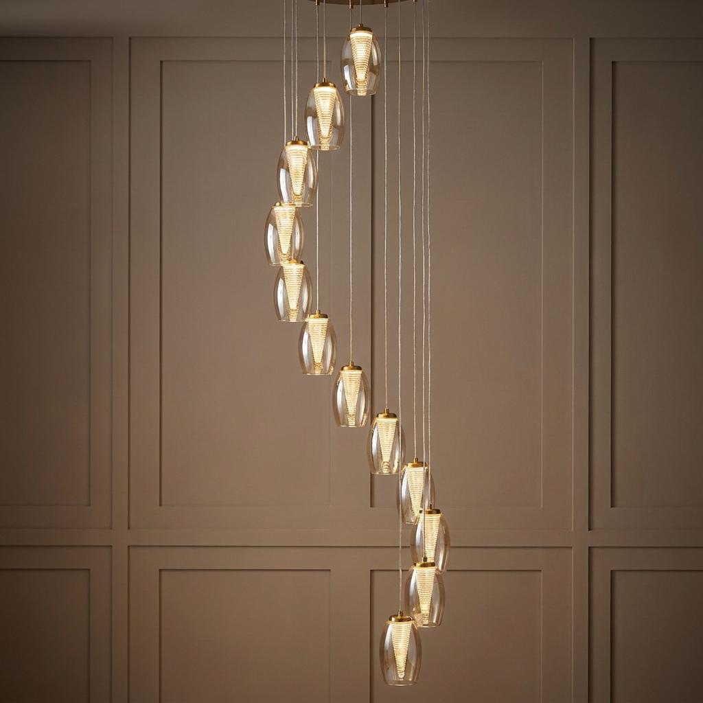 Bronze multi-drop 12-light pendant with champagne glass shades in a spiral arrangement against a paneled wall.