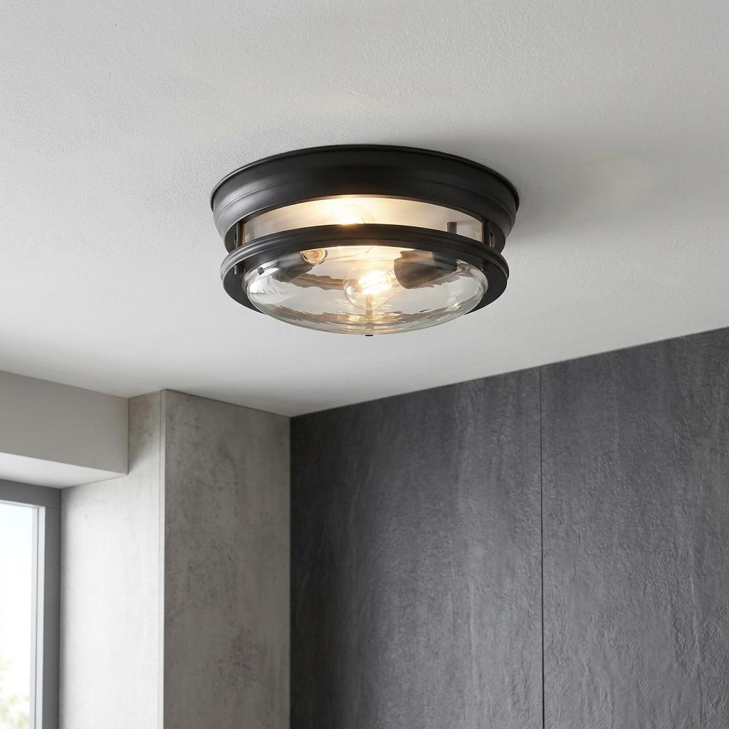 A black flush mount ceiling light with a clear glass shade illuminating a modern room.