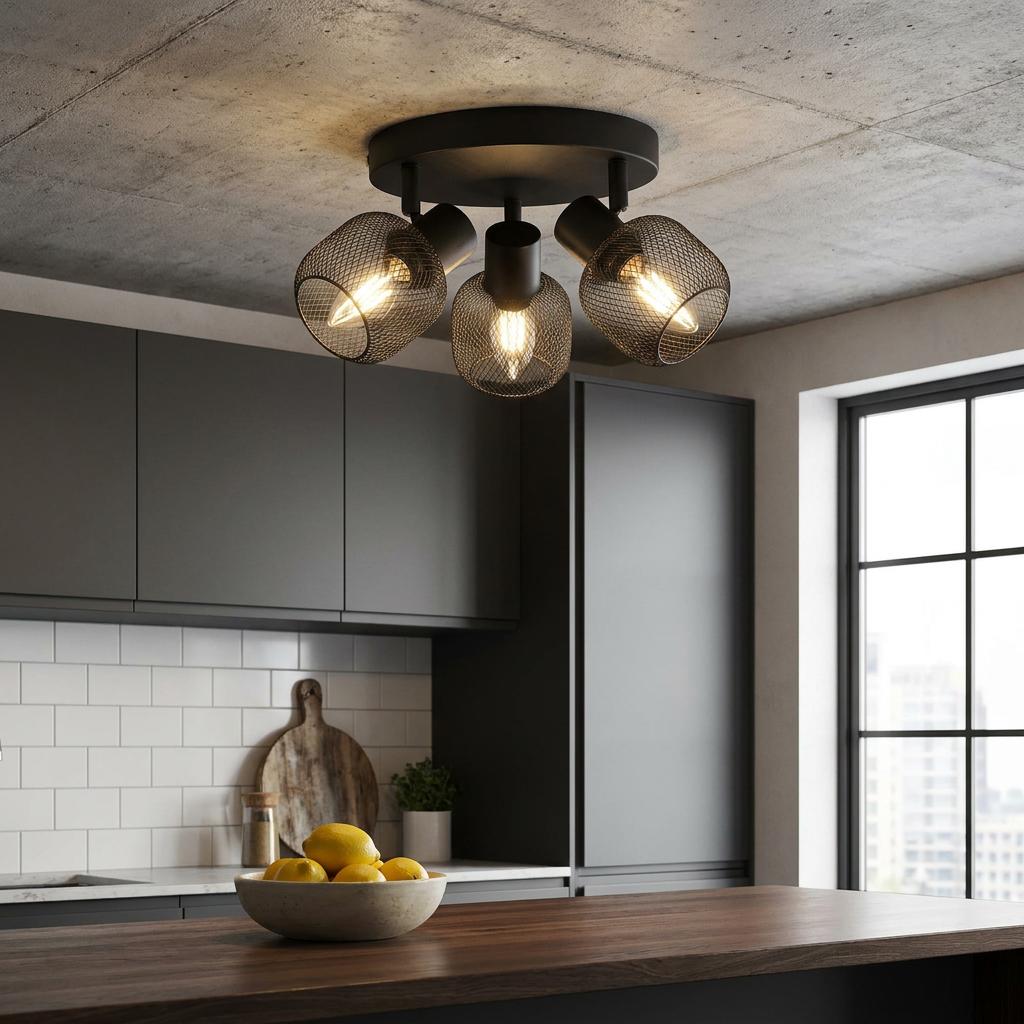 A three-light black mesh cage spotlight mounted on a concrete kitchen ceiling above a wooden island.