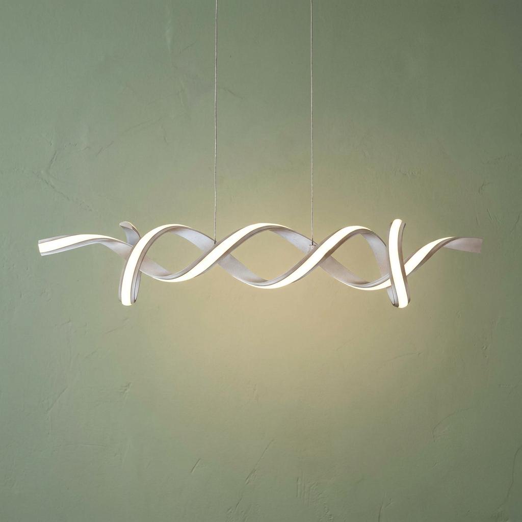 Satin silver helical LED pendant light with a twisted design hanging against a textured green wall.