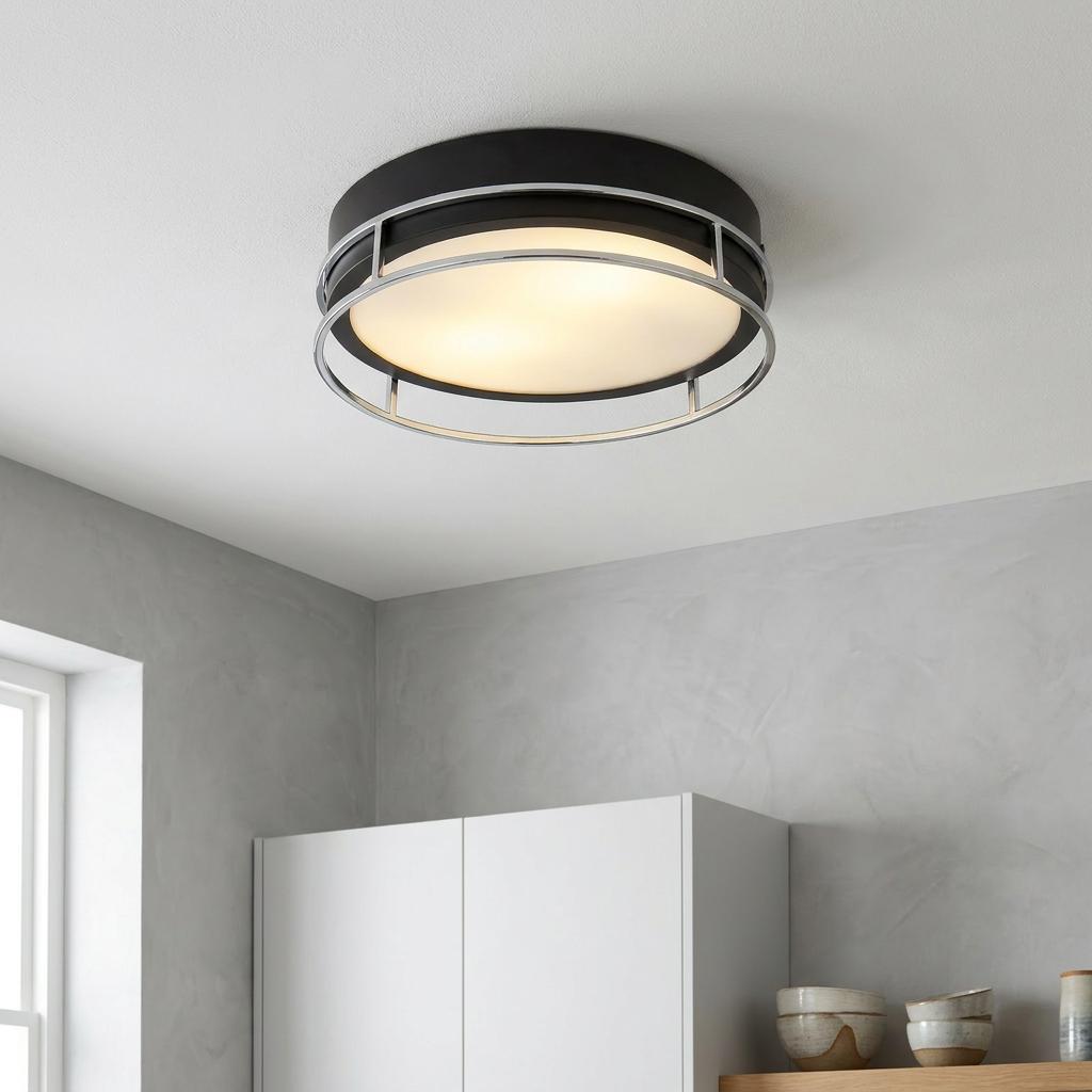 Modern matte black and chrome circular flush mount light with a glowing diffuser in a kitchen setting.