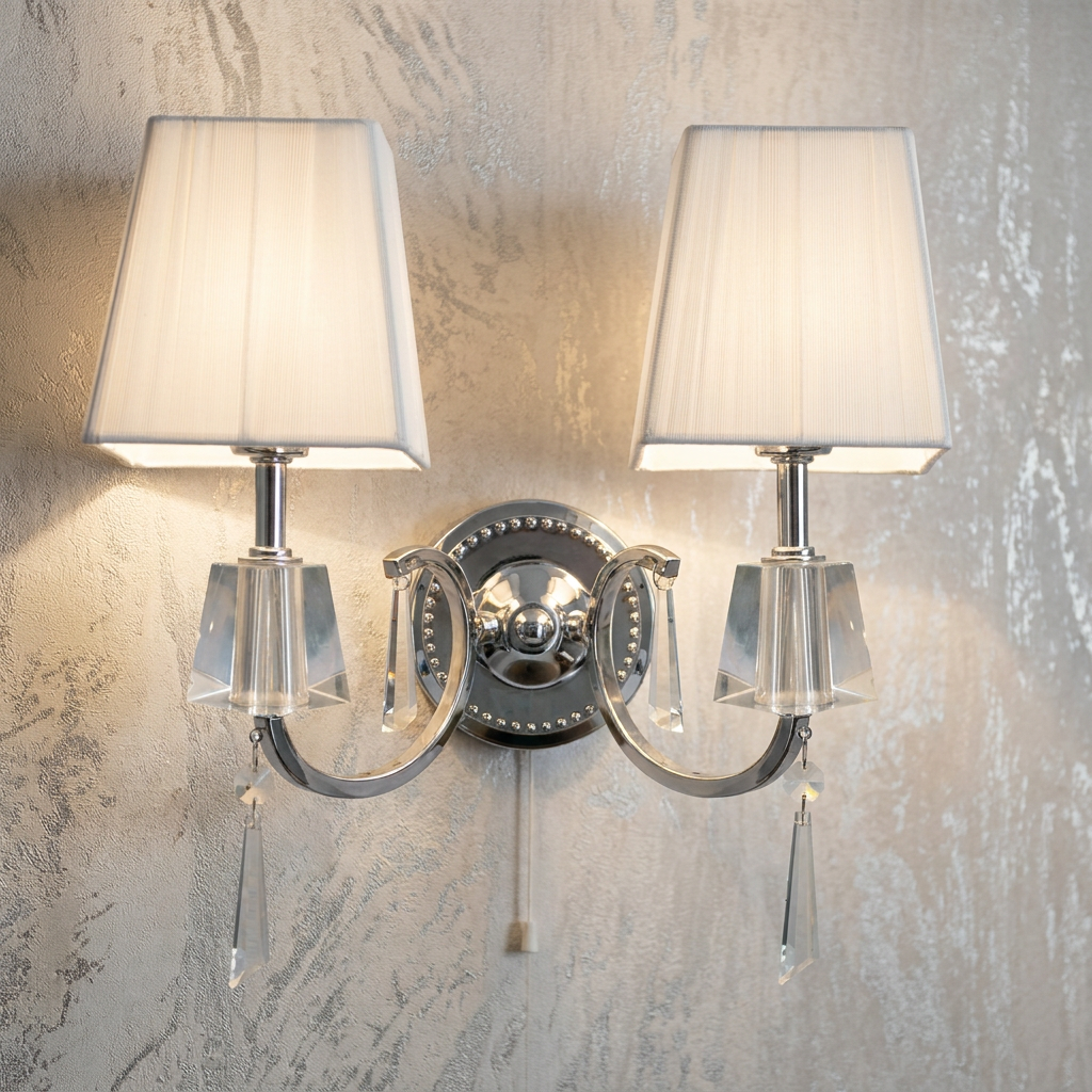 Double chrome wall light with white fabric shades and hanging crystal drops, mounted on a textured silver wall.