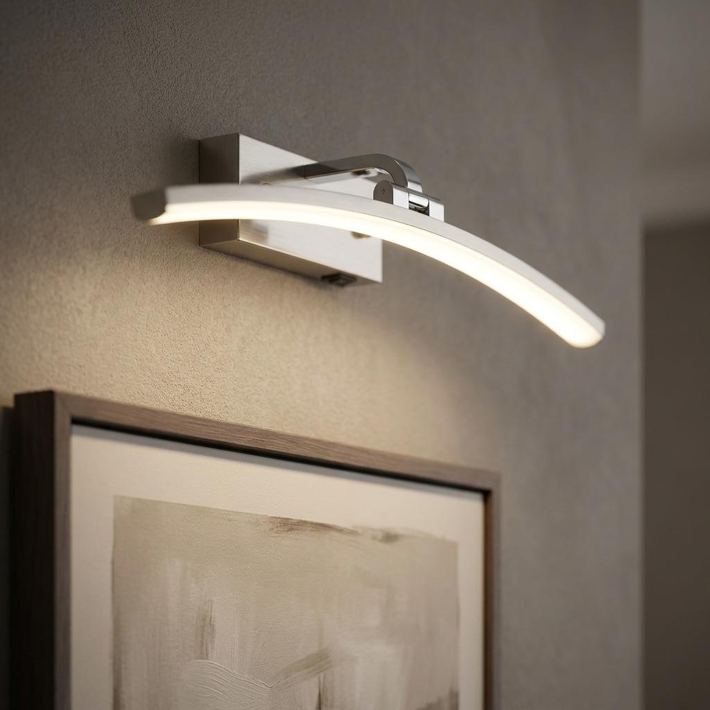 Modern curved silver LED picture light mounted on a textured wall illuminating a framed painting.