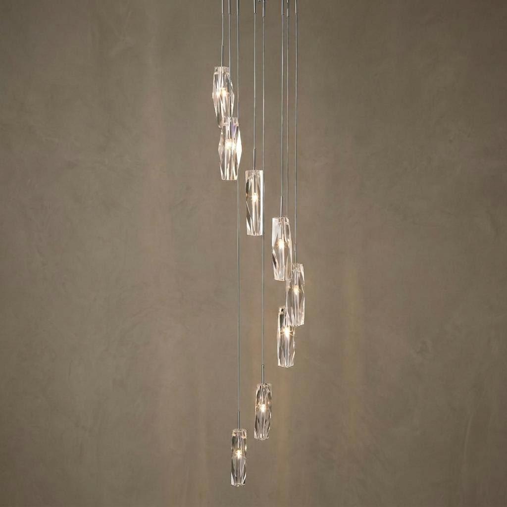 Cascading ten-light pendant with sculptured glass ice shades glowing against a neutral textured wall.
