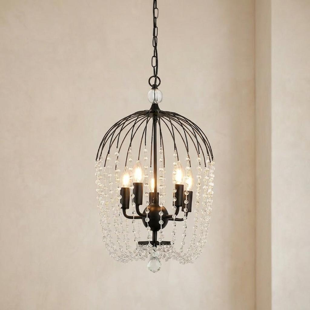 Five-light black birdcage ceiling pendant decorated with cascading clear crystal beads against a light wall.