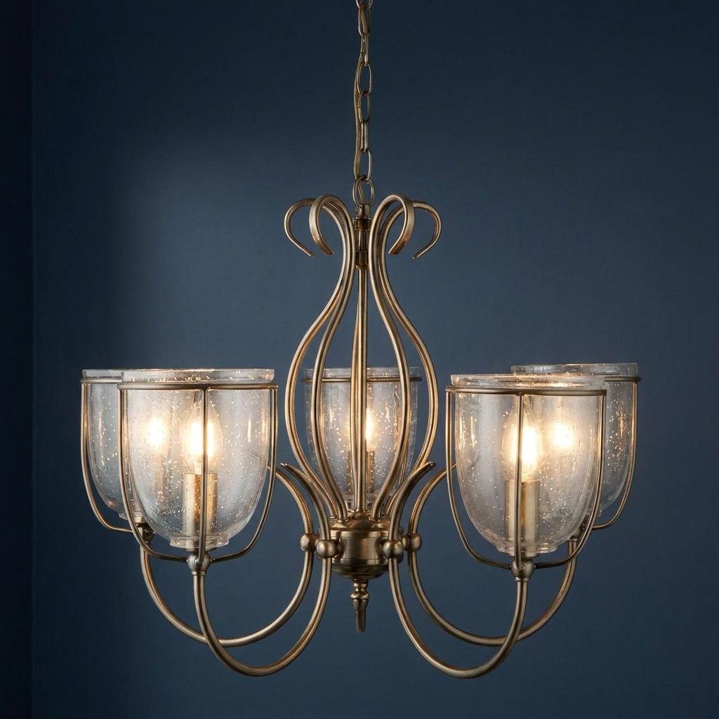 Silhouette 5-light brass pendant with seeded glass shades and elegant curved arms against a navy background.