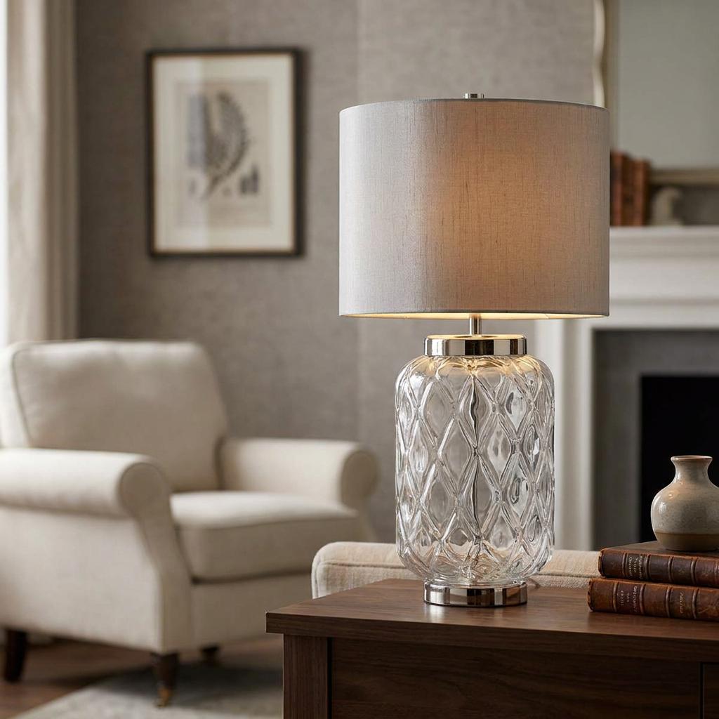 Sola glass table lamp with a diamond-patterned base and titanium shade on a wooden table in a living room.