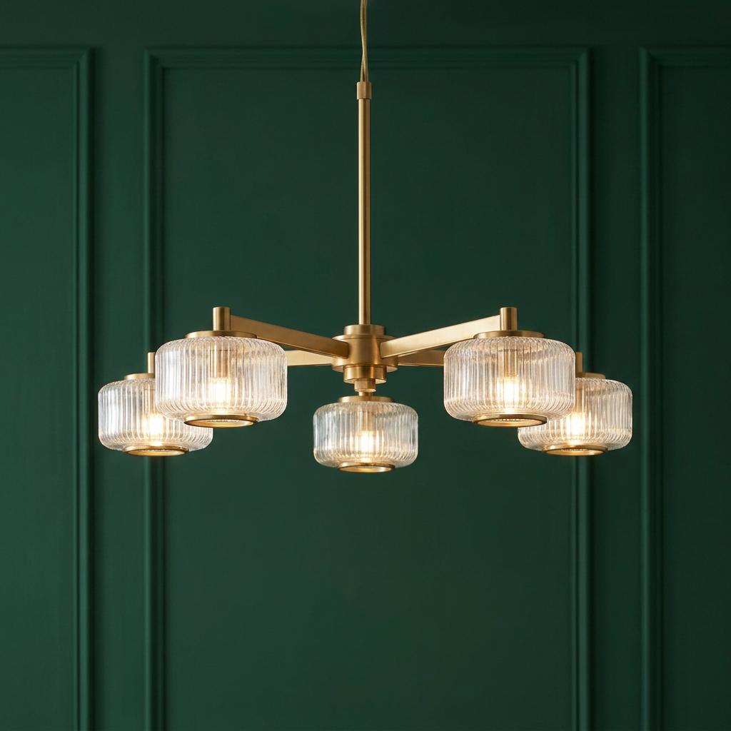 Five-light brass chandelier with ribbed glass shades hanging against a dark green paneled wall.