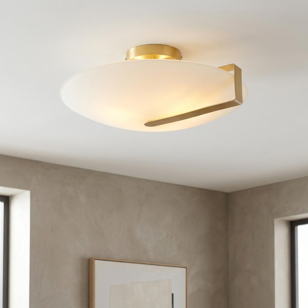 Sundial flush mount ceiling light with a frosted glass shade and satin gold metal arm against a white ceiling.