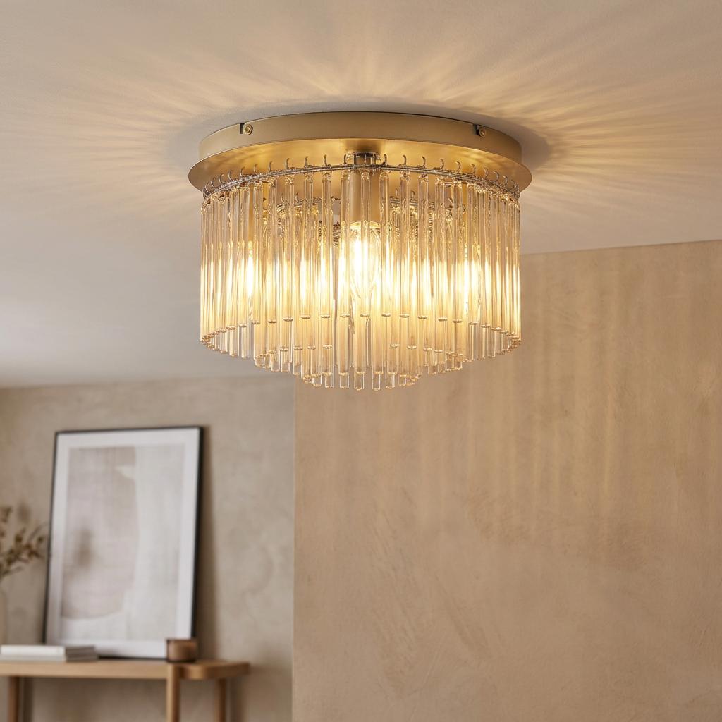 Gold flush mount ceiling light with champagne glass rods casting a warm glow in a modern room.
