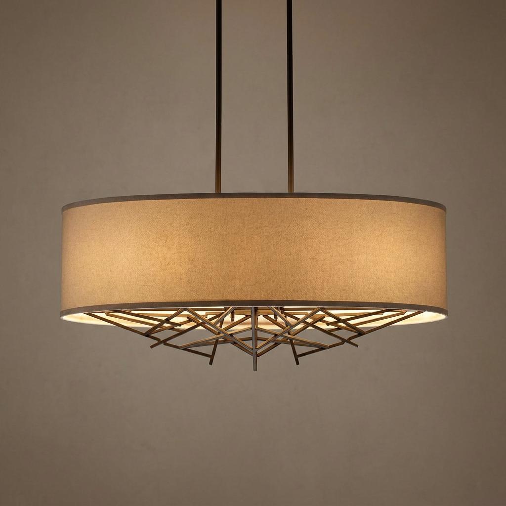 Modern brass kitchen island pendant with a beige fabric drum shade and an intricate geometric base.