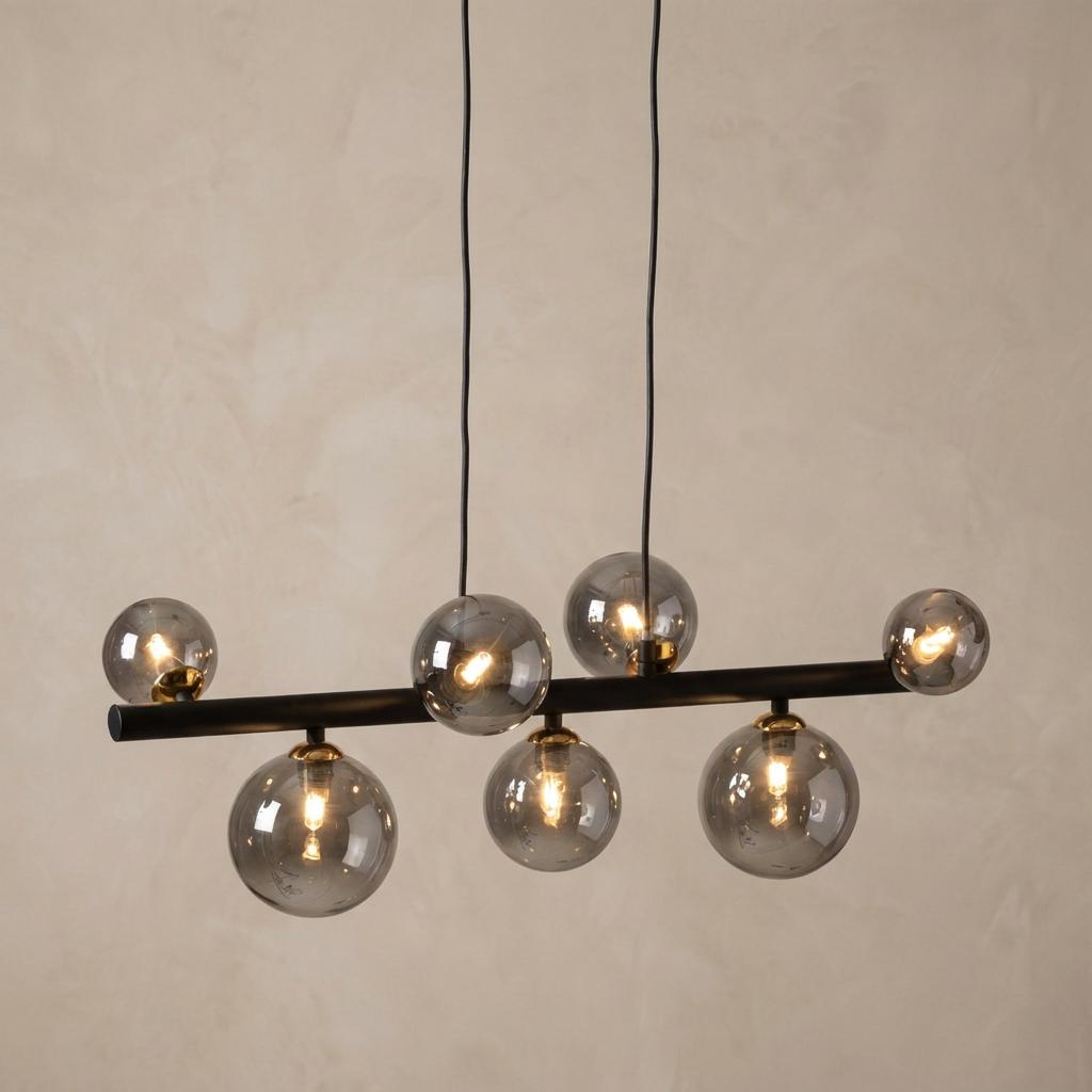 Tere 7-light pendant with smoked glass globes on a black horizontal bar with gold accents against a neutral wall.