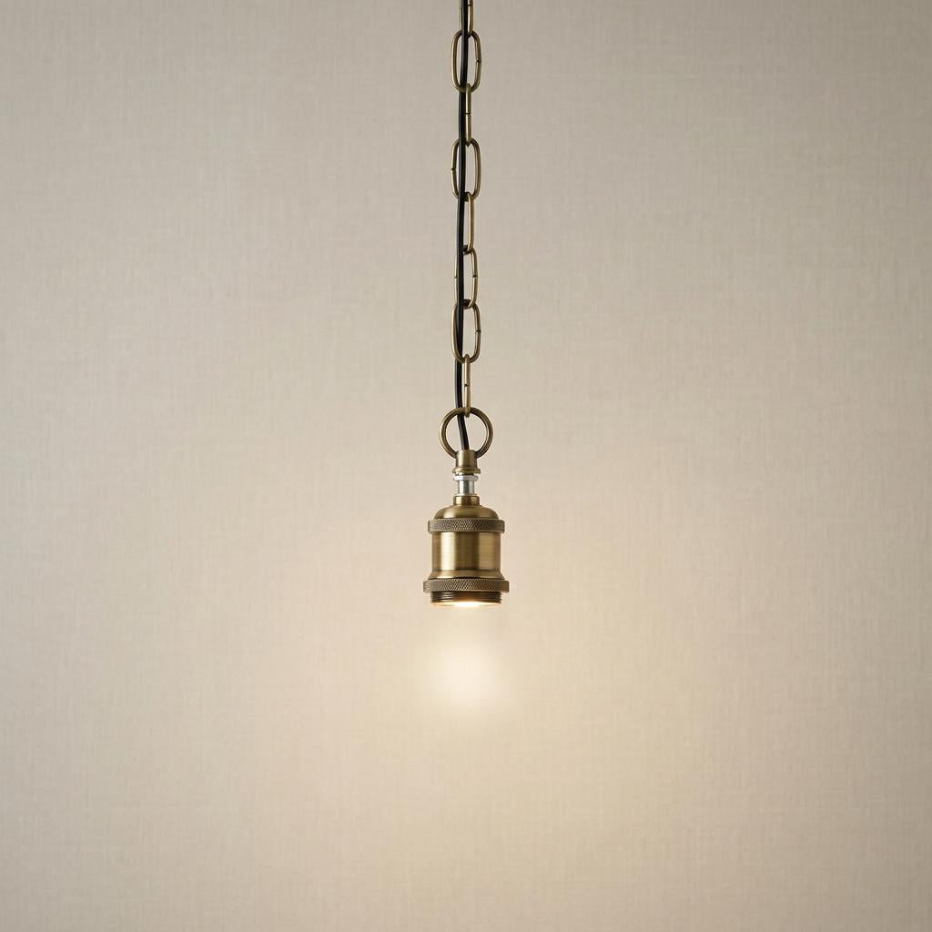 A light brushed brass Tiffany ceiling light chain set hanging against a neutral textured wall.