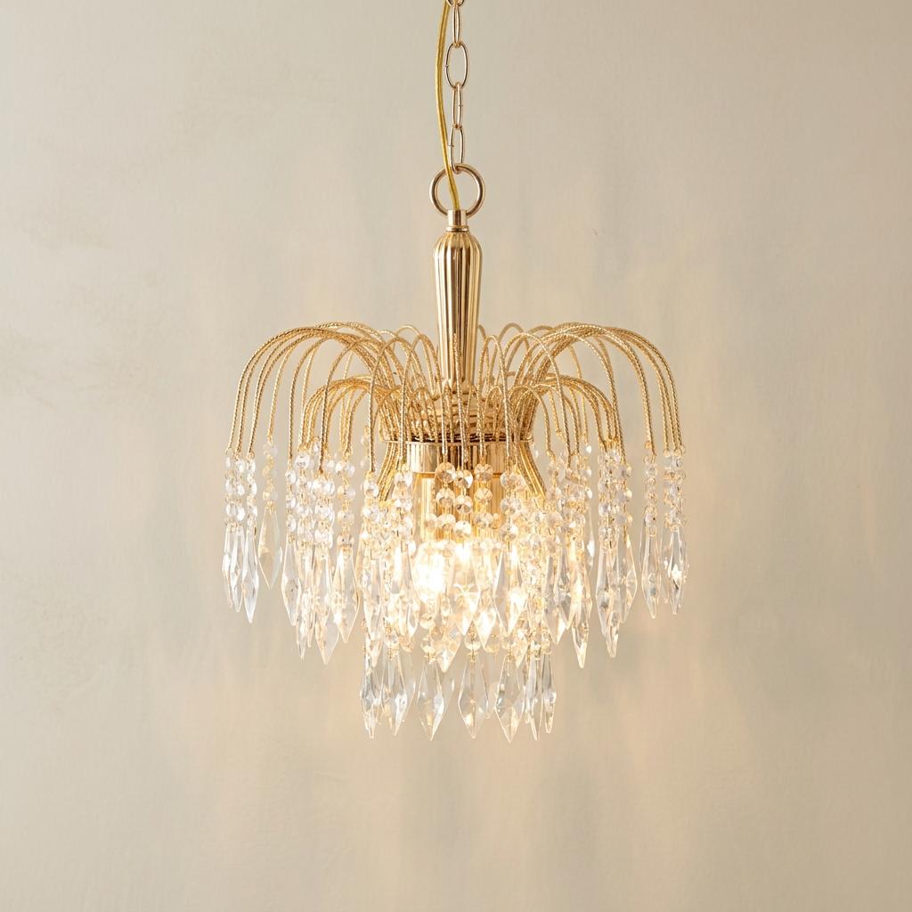 Waterfall 3-light gold and clear crystal ceiling pendant with lit bulbs against a neutral wall.