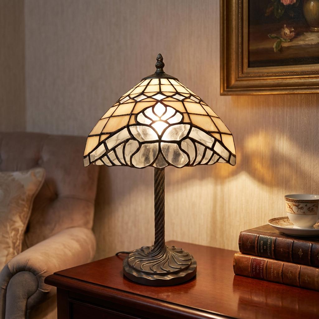 Welford Tiffany table lamp with a cream floral stained glass shade glowing on a dark wood side table.