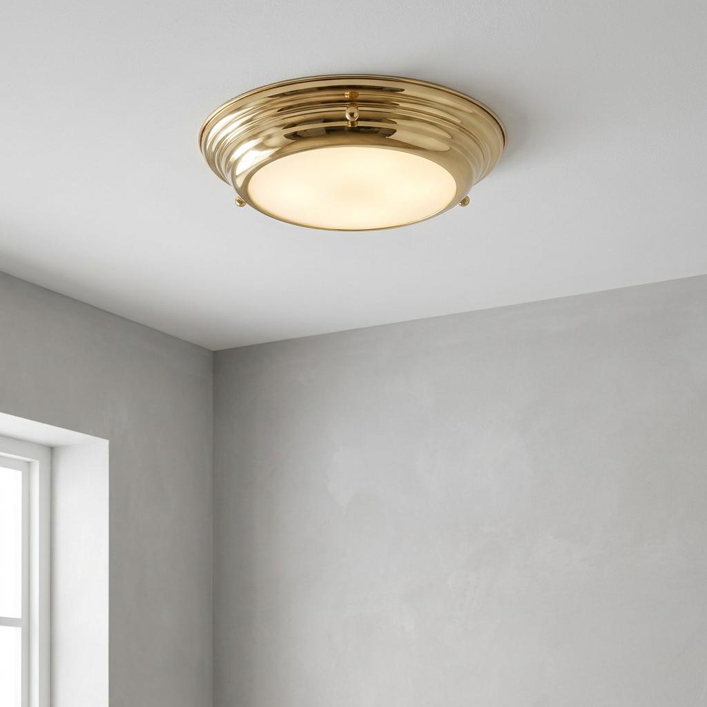 Polished brass mini LED flush bathroom ceiling light with frosted diffuser on a white ceiling.