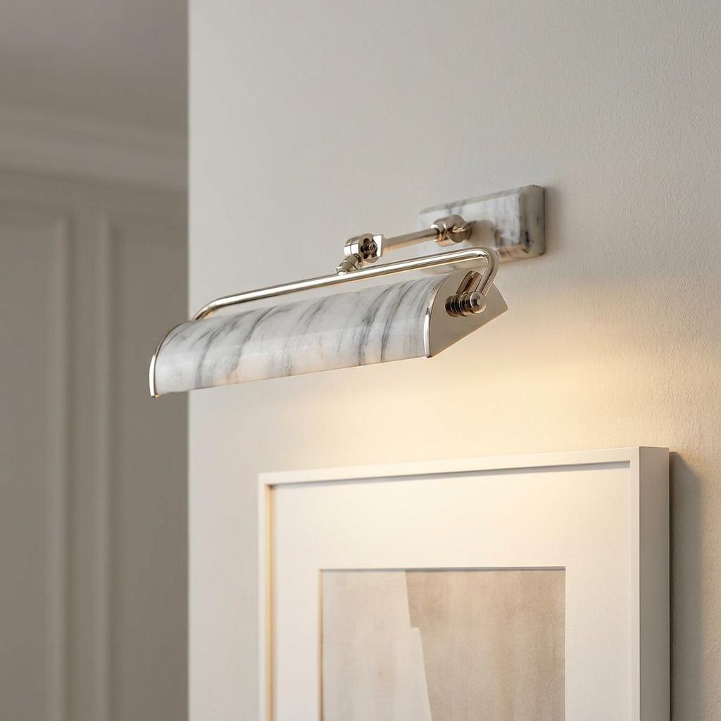 Marble effect picture light with silver hardware mounted on a wall, illuminating a framed piece of art.