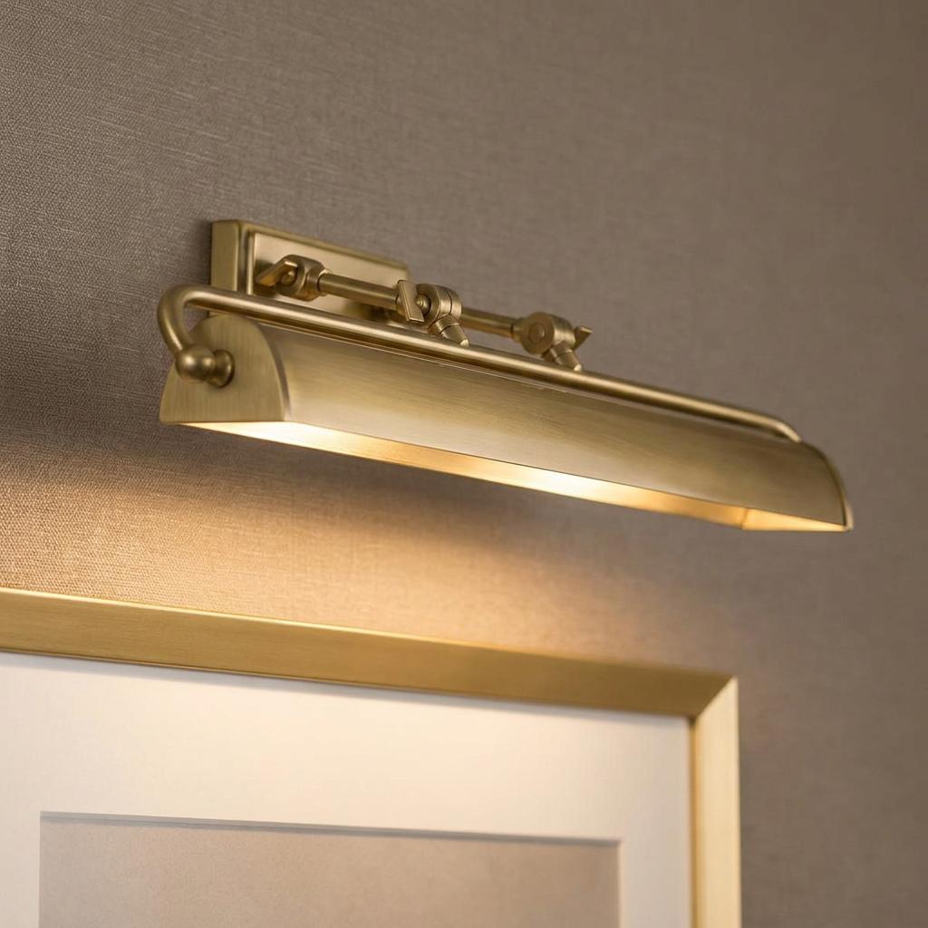 Winchfield large brass picture light mounted on a wall, illuminating a framed picture below.