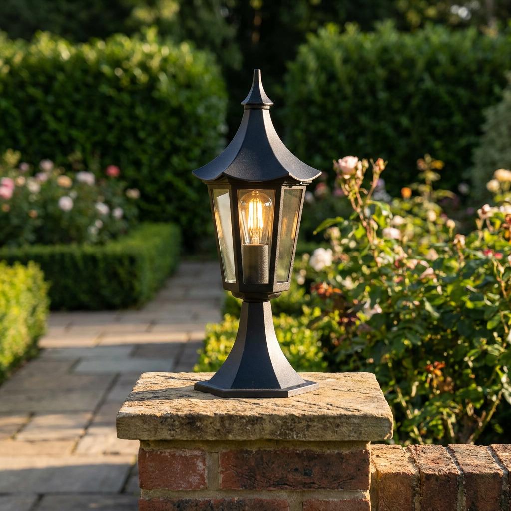 Black pagoda-style lantern with a warm glowing filament bulb, mounted on a stone garden pillar.