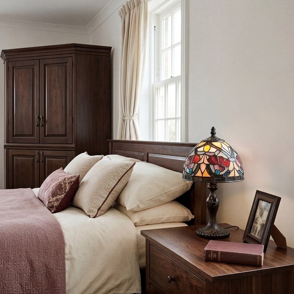 Bedroom with wooden wardrobe, bed with pillows, stained glass lamp, and framed photo.