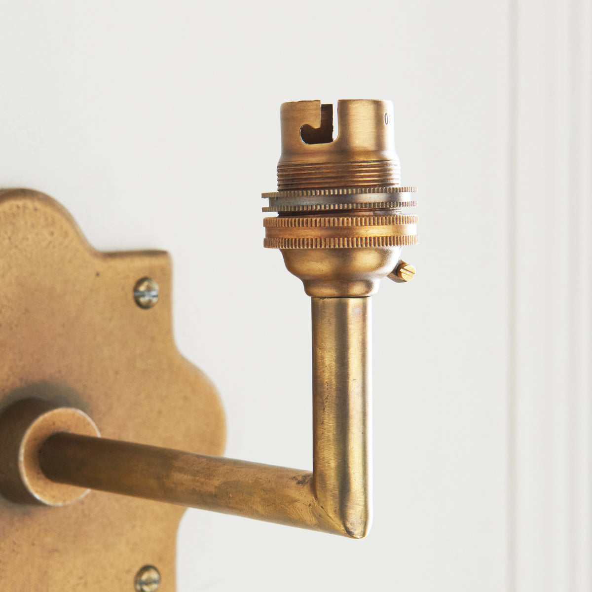 Close-up of the brass bayonet bulb holder on the angled arm of the Anvil Angle wall light
