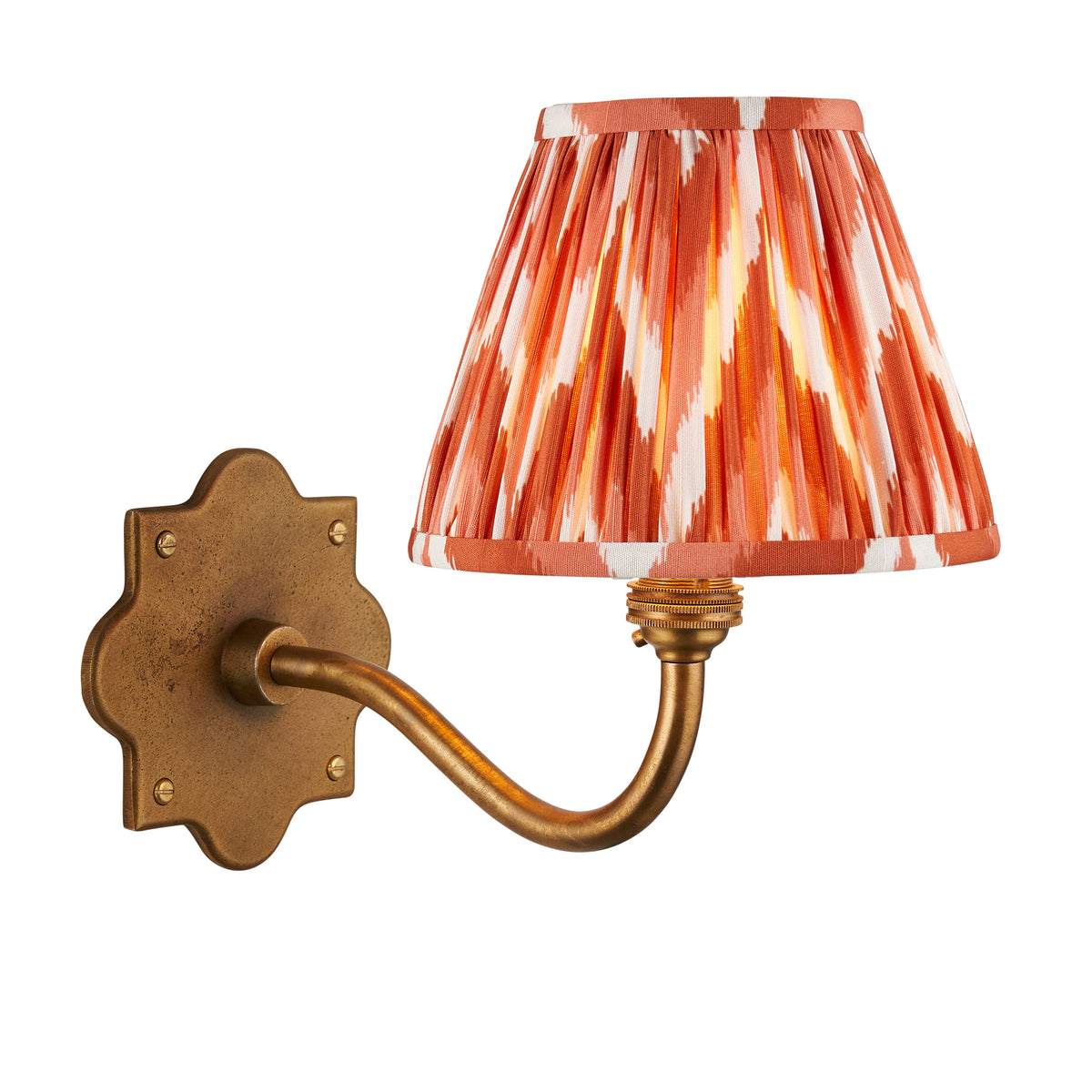 Anvil Curve antique brass wall light with orange zigzag ikat pleated shade on a white background