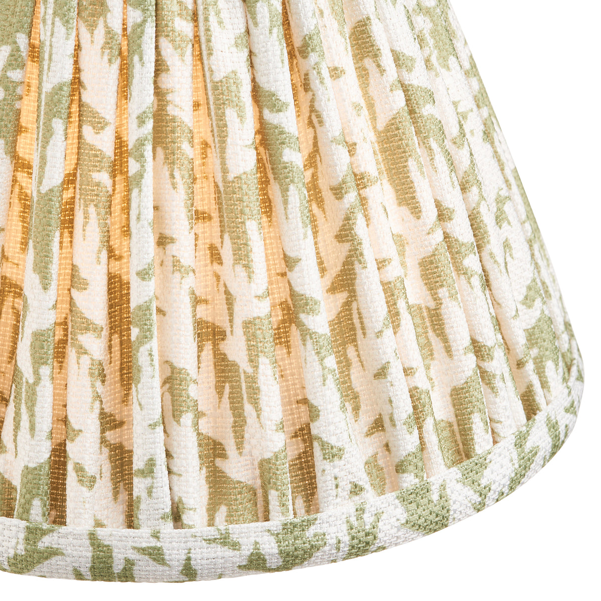 Close-up of the green leaf-print pleated fabric shade and its bound cream lower edge
