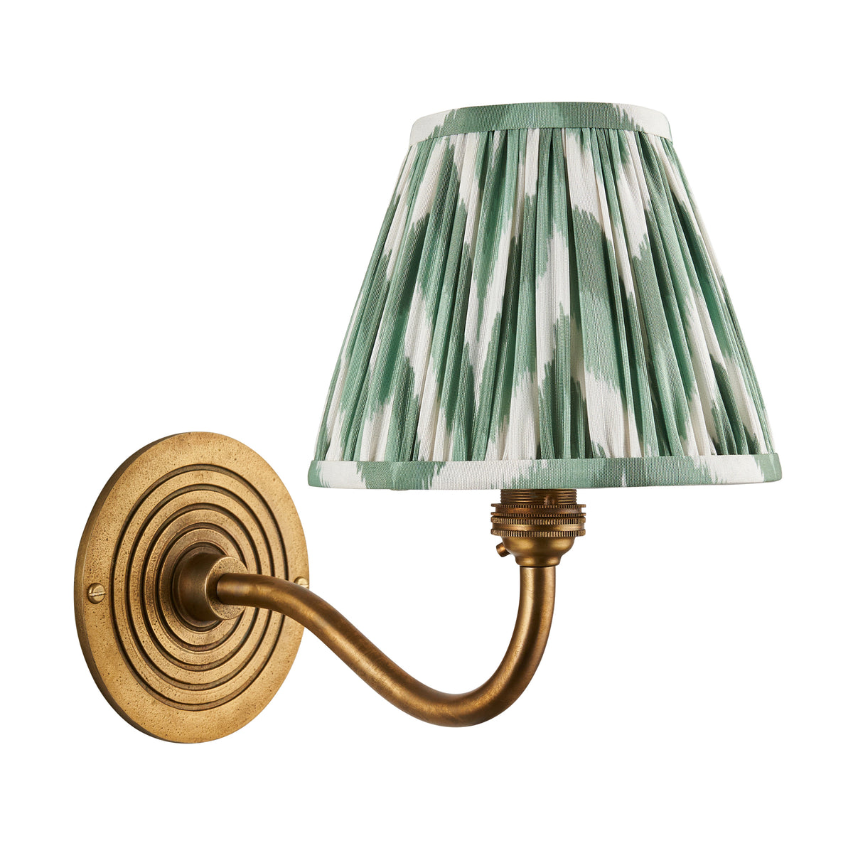 Ripple Curve antique brass wall light with green zigzag ikat shade, cut out on white