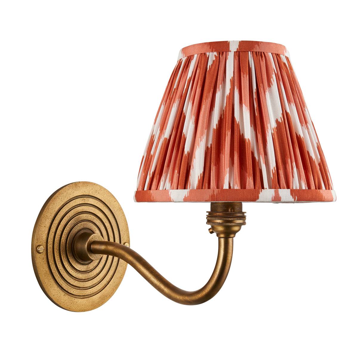 Ripple Curve antique brass wall light with orange ikat pleated shade, cut out on white background