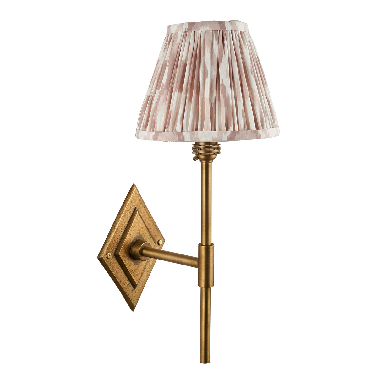 Diamond antique brass wall light with dusky pink and cream ikat pleated shade on white background